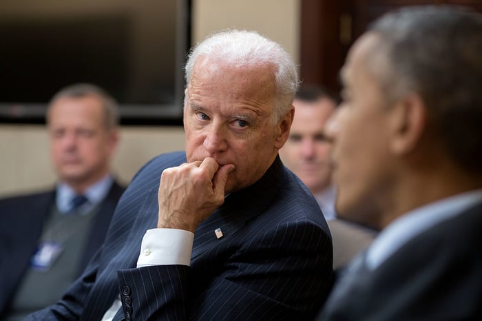 Joe Biden listening to former President Barack Obama in a meeting.