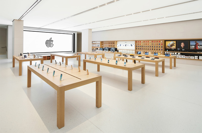 Tables displaying Apple devices at an Apple store.