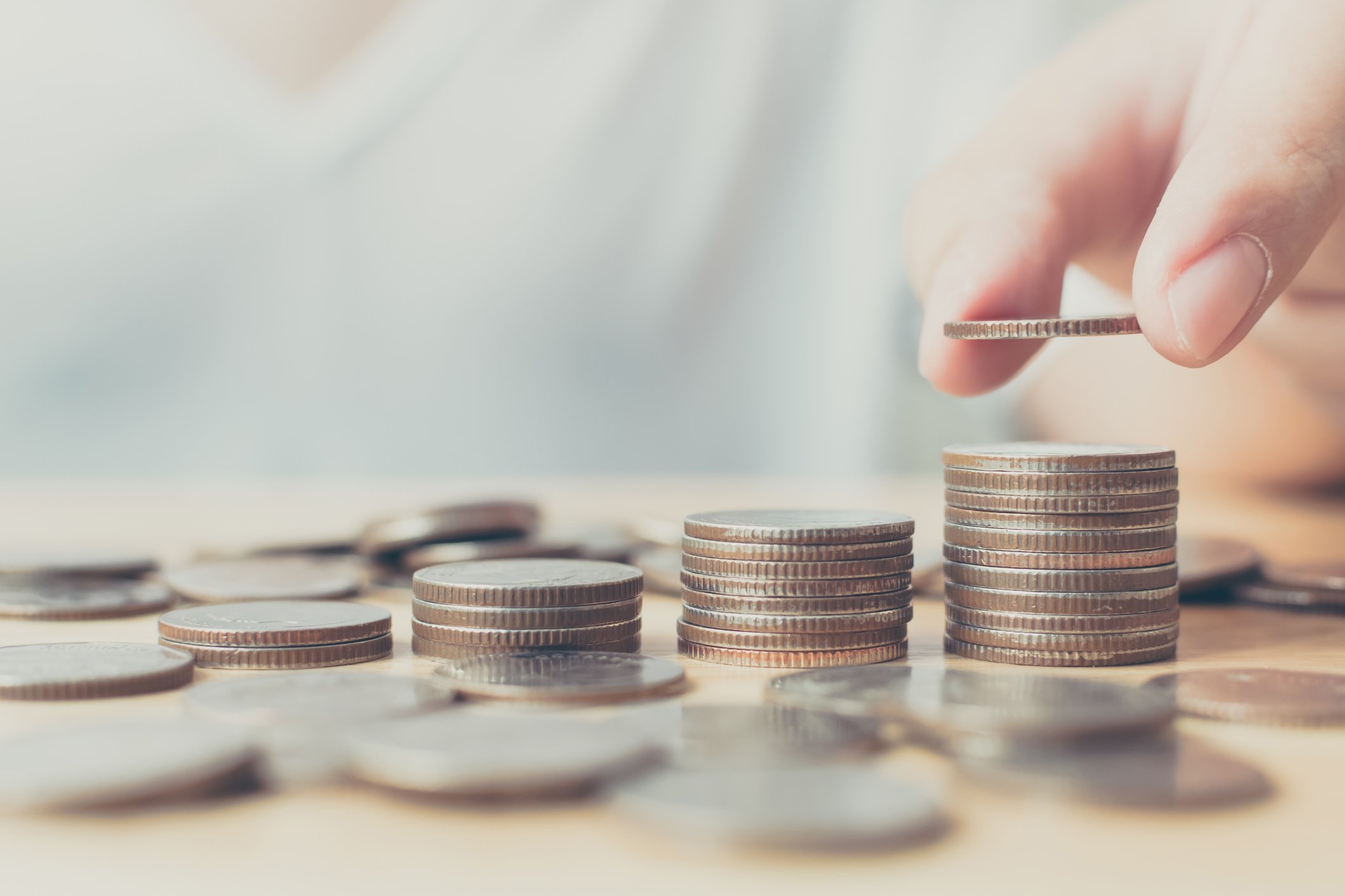 Close-up of hand stacking coins. 