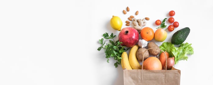 A grocery bag with fruits and vegetables coming out of it