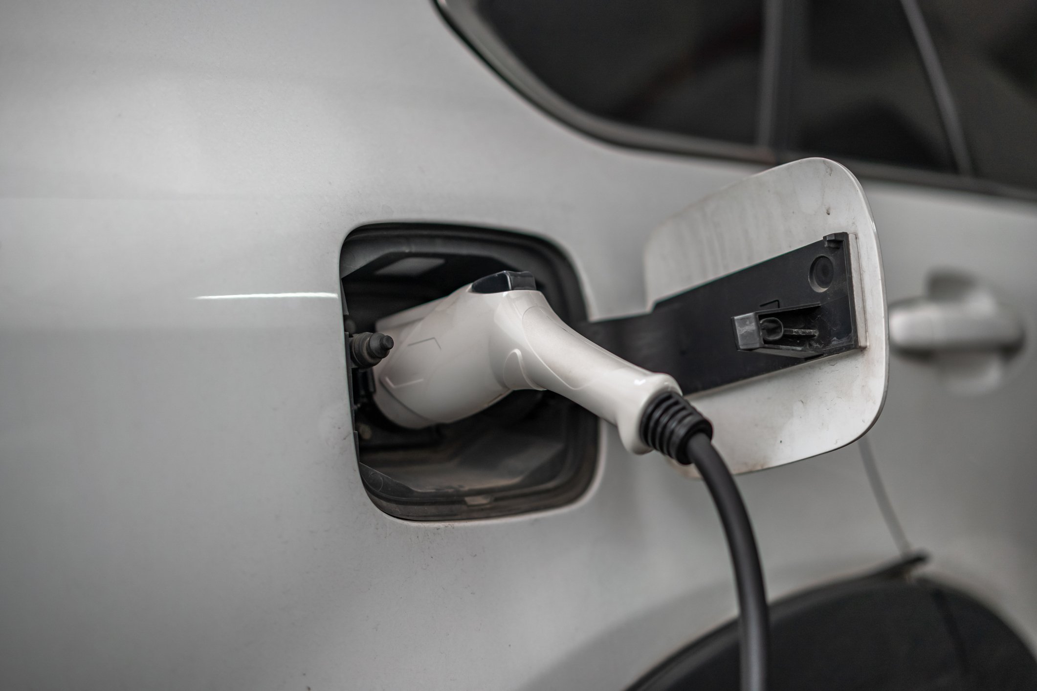 closeup of an electric vehicle being charged. by a plug.