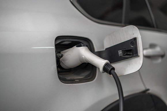 closeup of an electric vehicle being charged. by a plug.