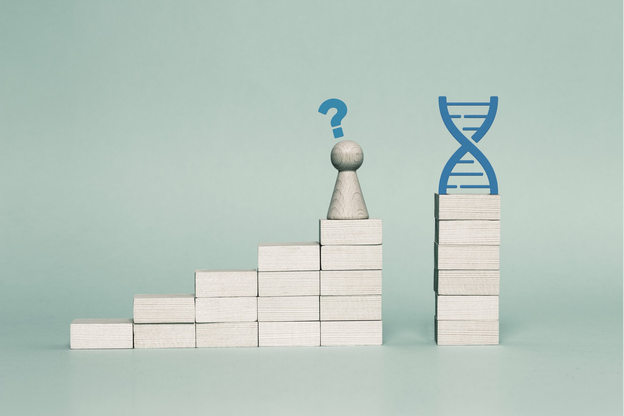 Ascending stacks of blocks with a gap between the last two stacks, a chess pawn with a question mark over it on top of the next-to-last stack, and a DNA image over the last stack. 