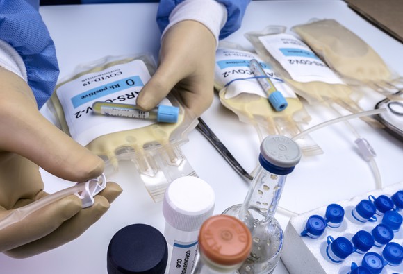 A doctor holding bags of human plasma.