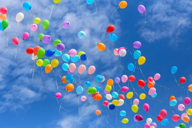 Many balloons against a blue sky