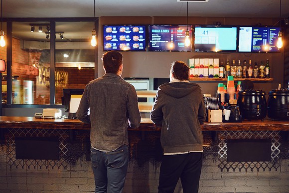 Customers at a counter in a fast-food restaurant