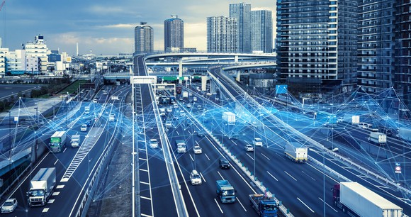 Cars driving on an urban freeway and blue lines signifying wireless linkages.