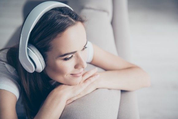 Woman enjoying listening to content on wireless headphones.
