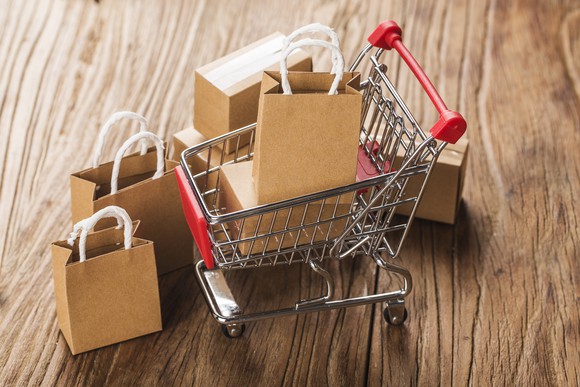 Tiny shopping bags in a tiny shopping cart.