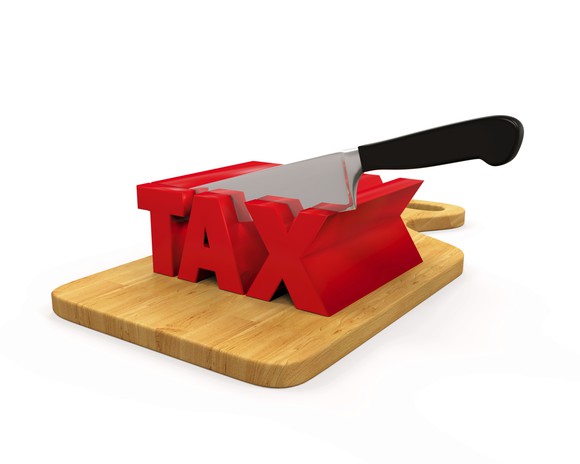 We see a knife cutting a 3-d representation of the word tax.