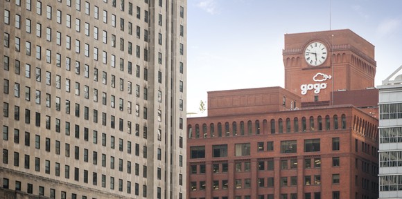 Gogo logo on side of building with a large clock above it
