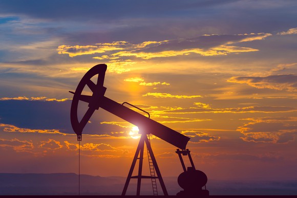 A pumpjack with the background of a sunset. 