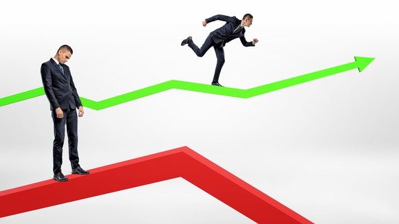 One businessman stands passive on a red arrow pointing downward and another running on a green arrow pointing upward.