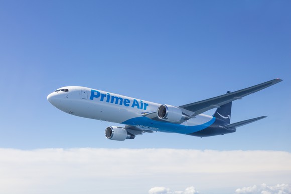 An Amazon Prime Air plane flying through the blue sky.