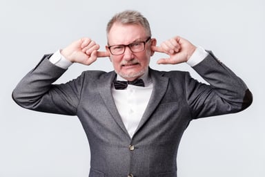 Old man plugging ears