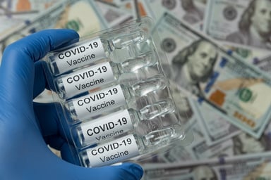 COVID-19 vaccine bottles over $100 bills