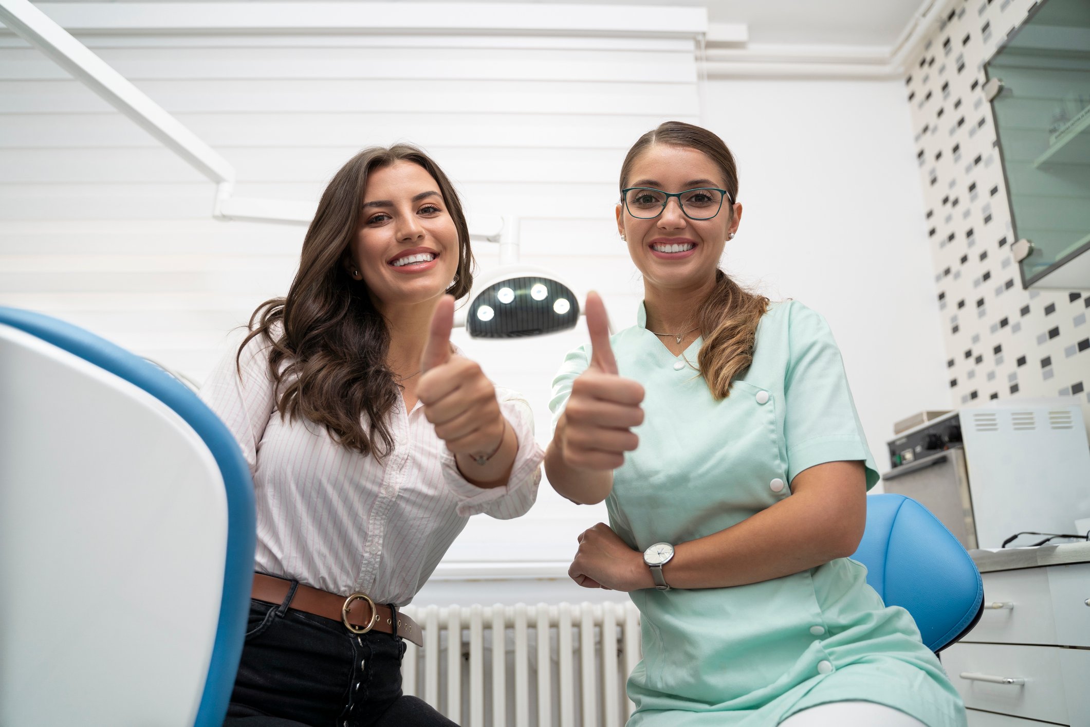 Two healthcare professionals with their thumbs up.