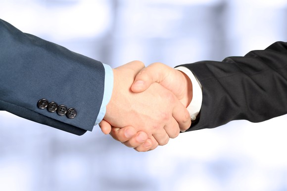 Two people in business suits shaking hands
