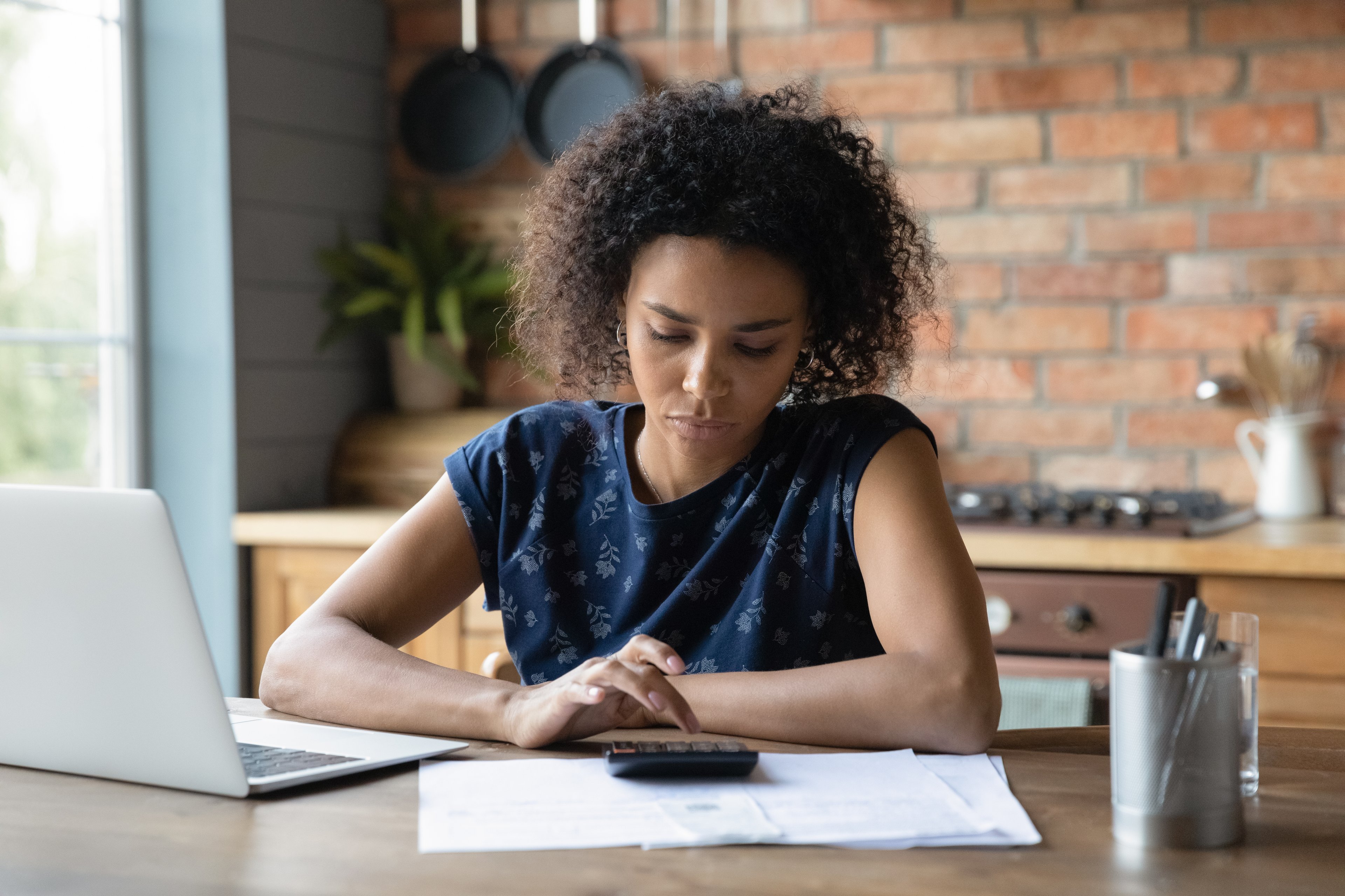 Adult sitting at table looking at financial paperwork. 