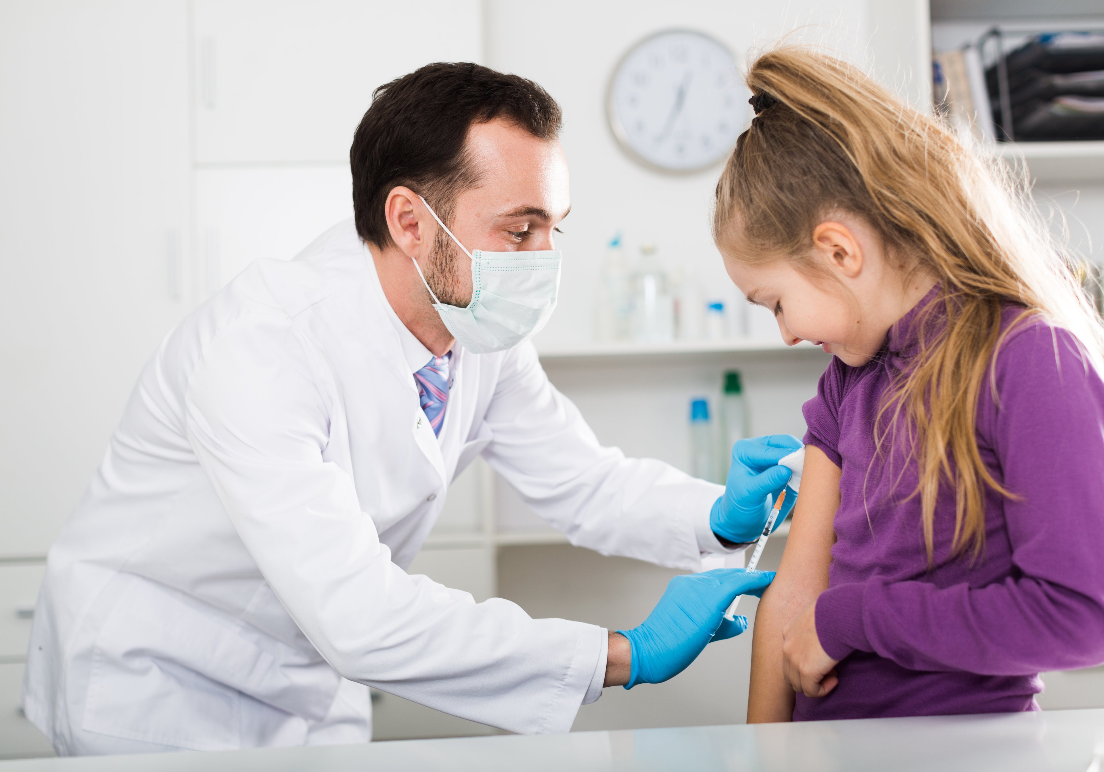 Doctor giving child a vaccine shot.