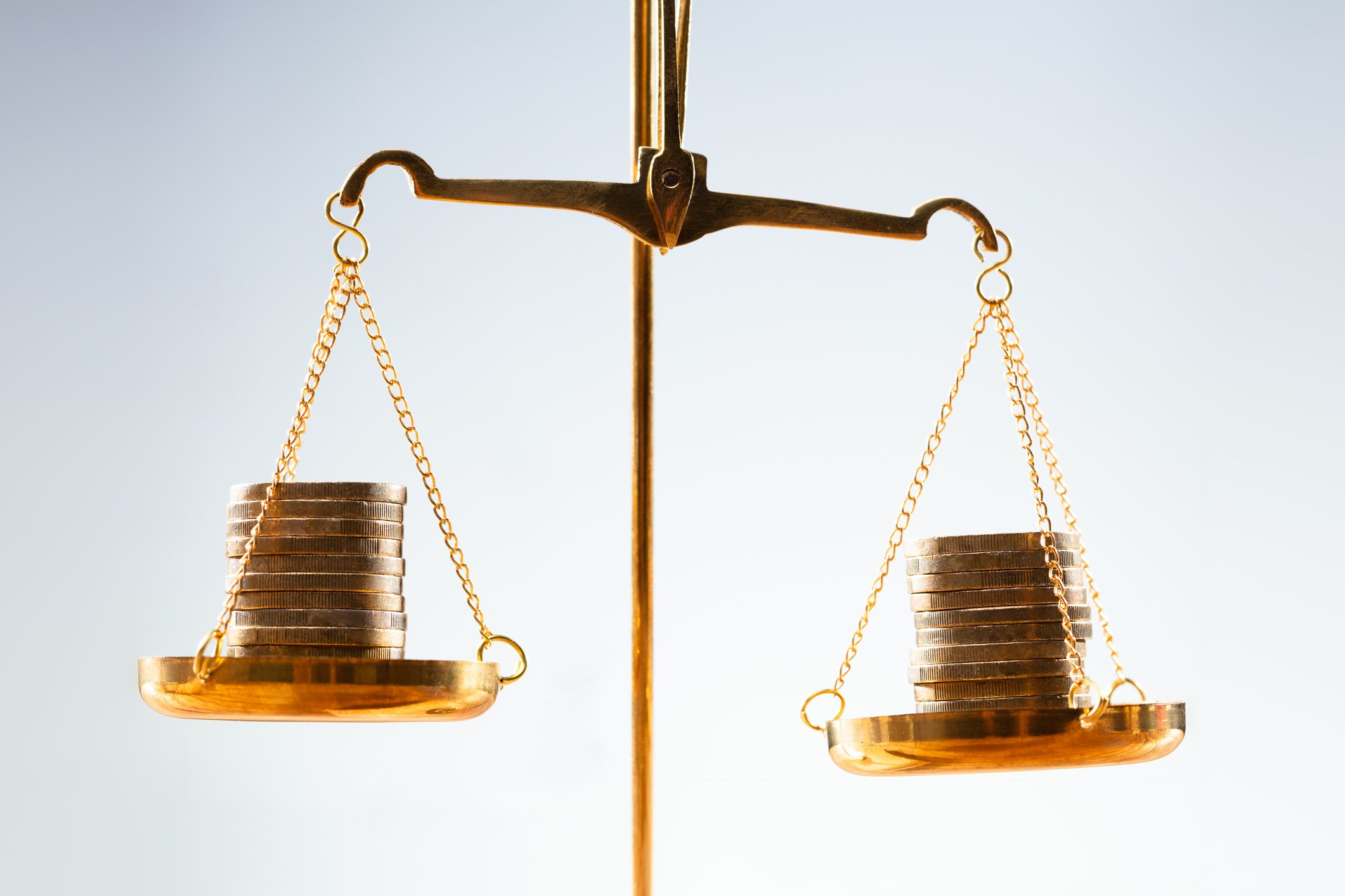 Two stacks of coins are balancing on scales.