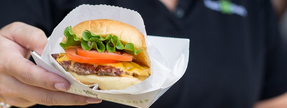 A Shake Shack burger in a paper wrapper