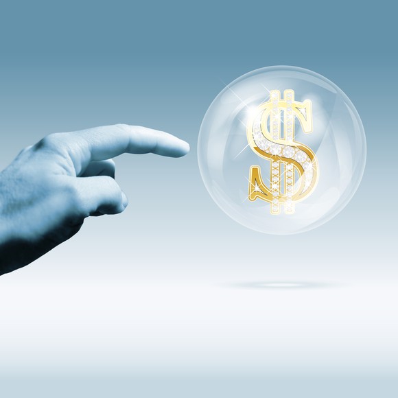 Hand pointing to a bubble with a dollar sign inside it. 