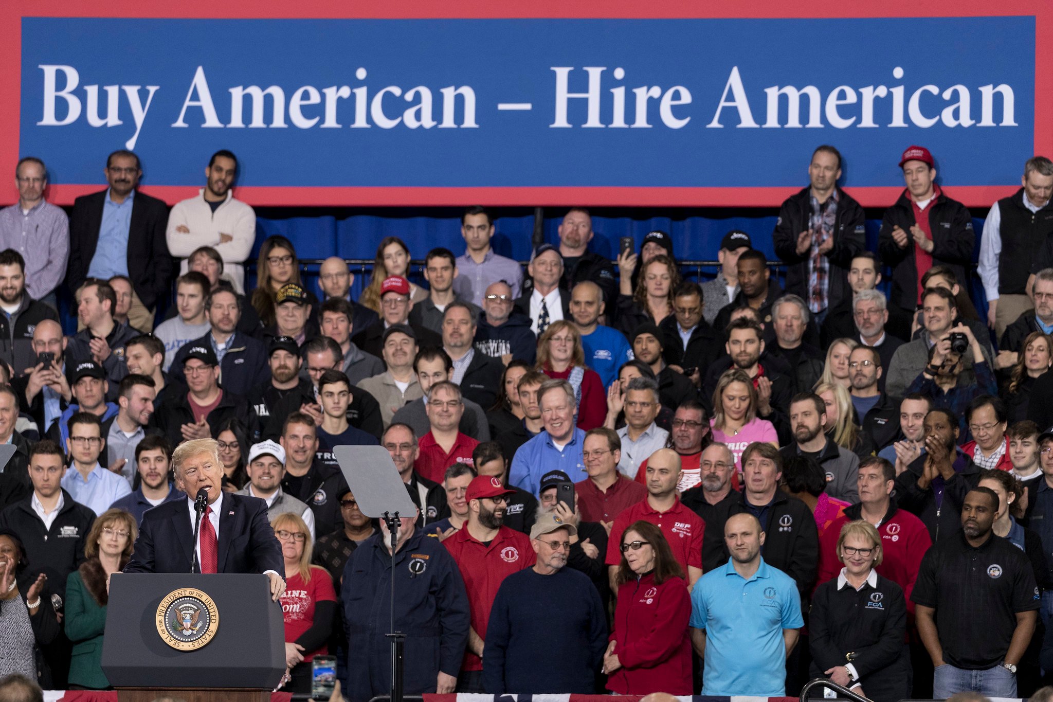 President Trump speaking to a large audience. 