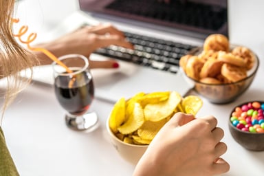 Girl snacking while working at a computer