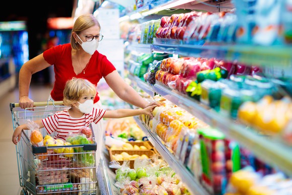 Woman grocery shopping with a child.