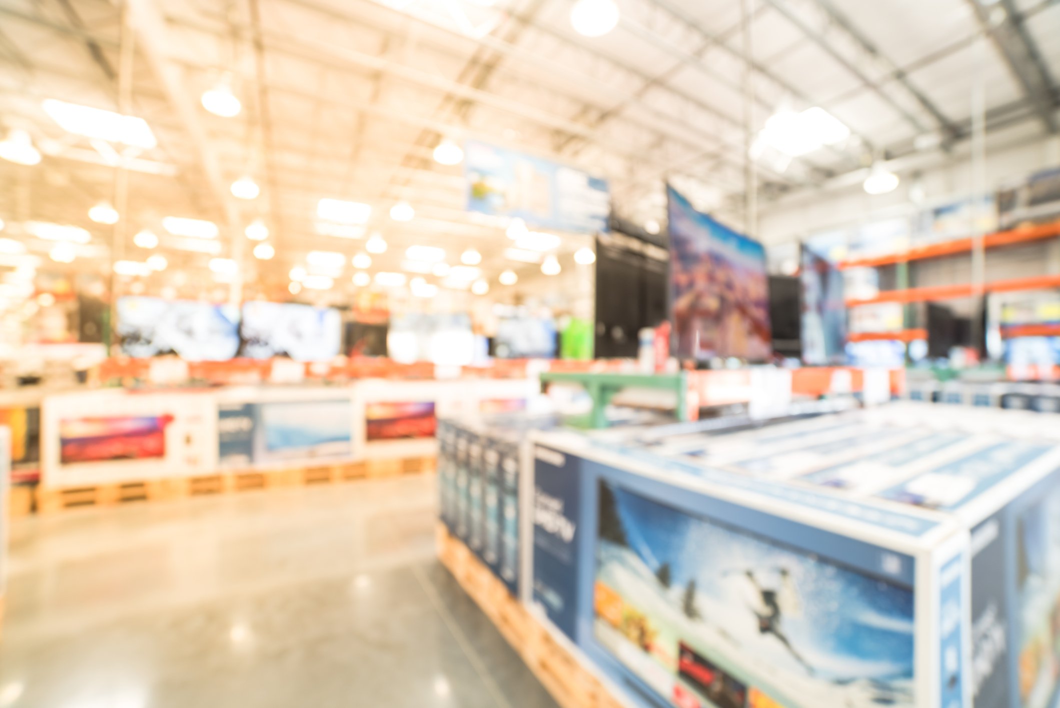 Boxed television screens and other electronics in a large warehouse club store.