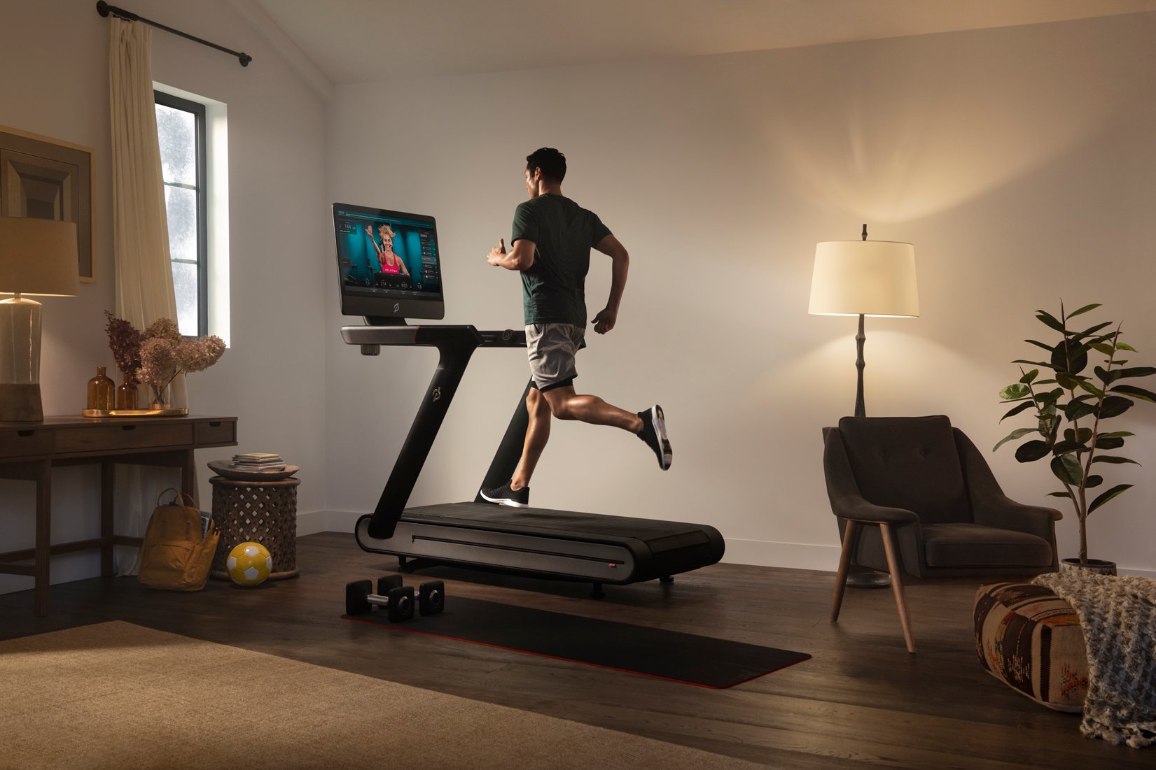 A man running on a Peloton treadmill.