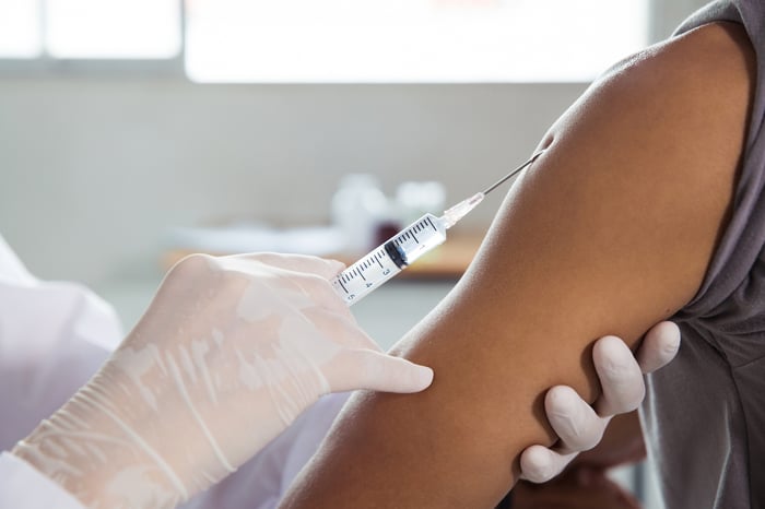 Physician holding syringe to patient's arm.