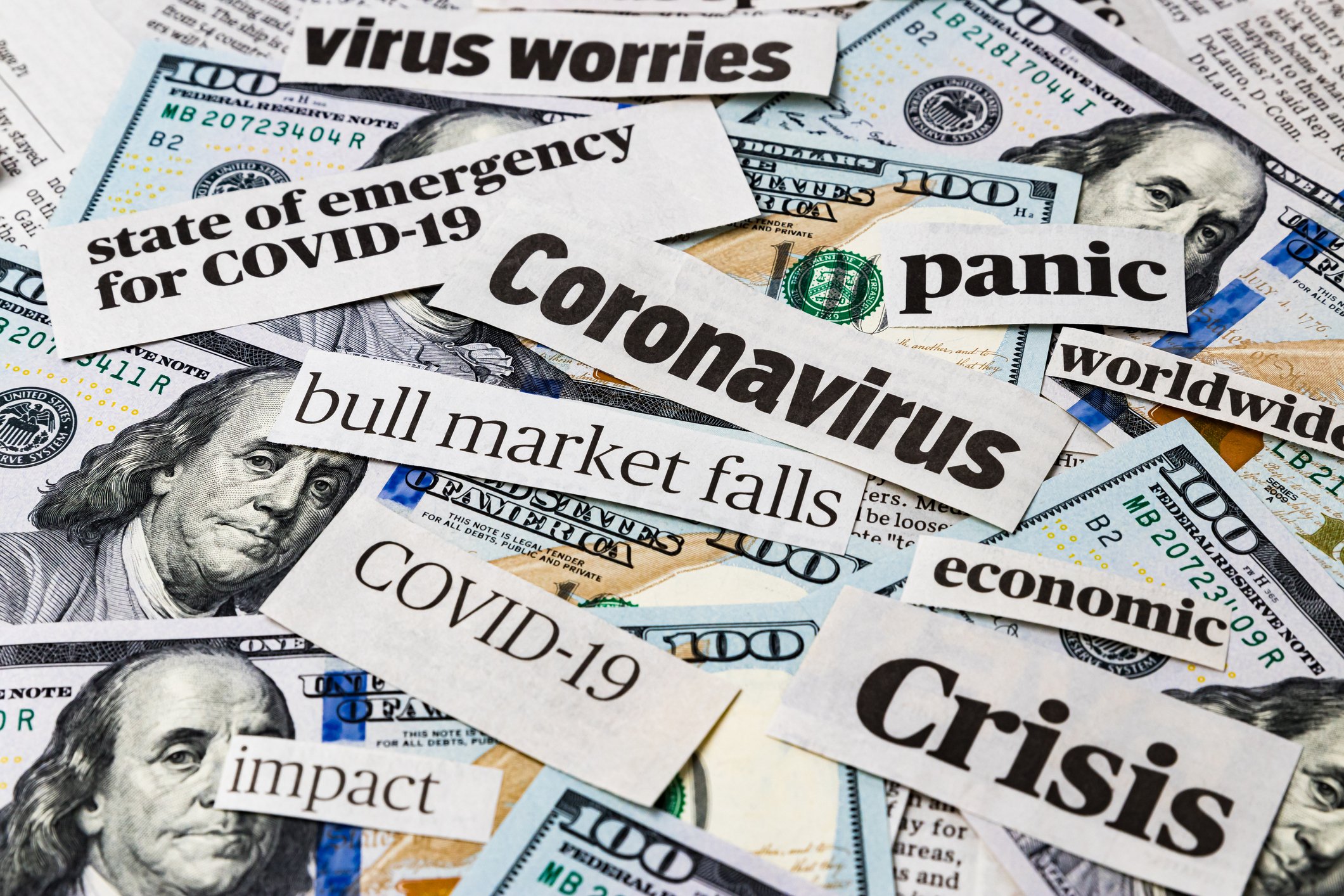 Panic-inducing headlines about the coronavirus clipped out and mixed with hundred-dollar bills.