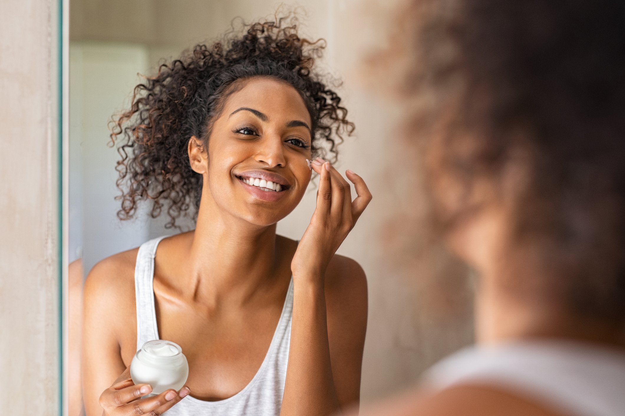 Woman applying face cream.