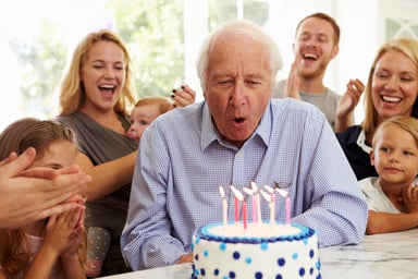 senior man blowing out candles_
