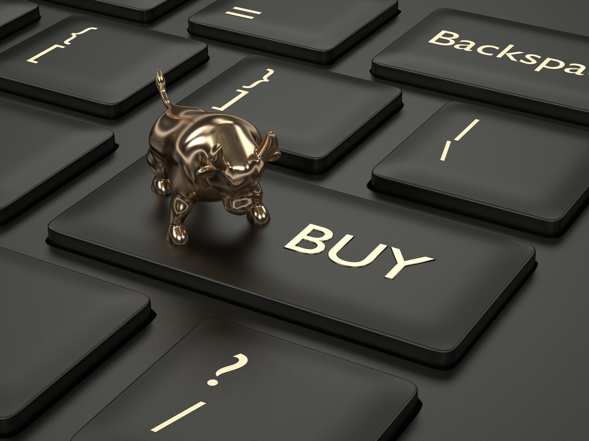 A miniature gold bull is on top of a keyboard button labeled buy.