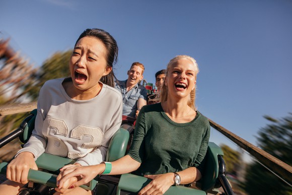 Two friends ride a roller coaster.