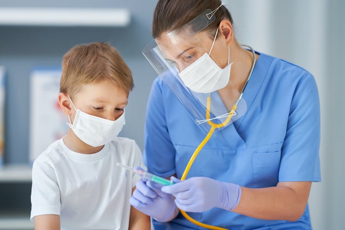 Nurse showing a syringe to a child