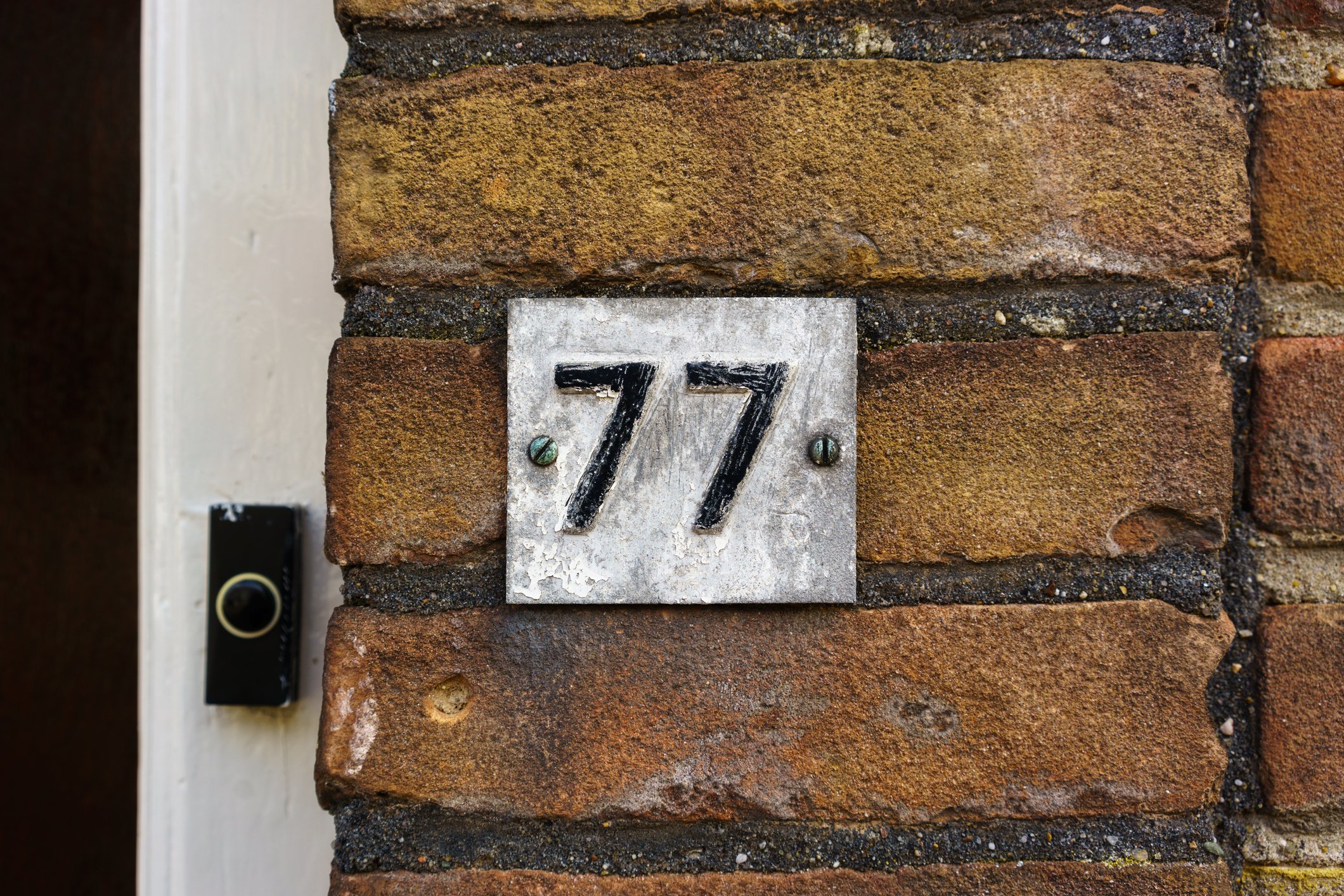 Number 77 on a brick wall