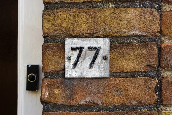 Number 77 on a brick wall