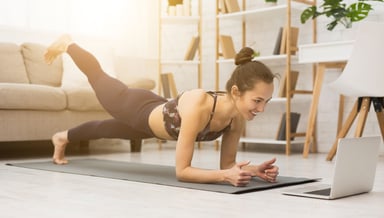Woman working out with her computer at home