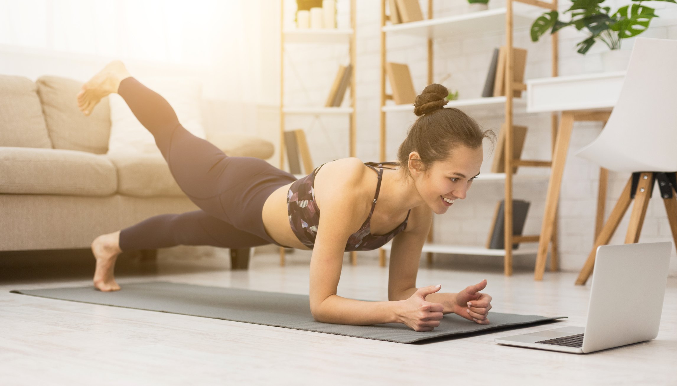 Woman working out with her computer at home.