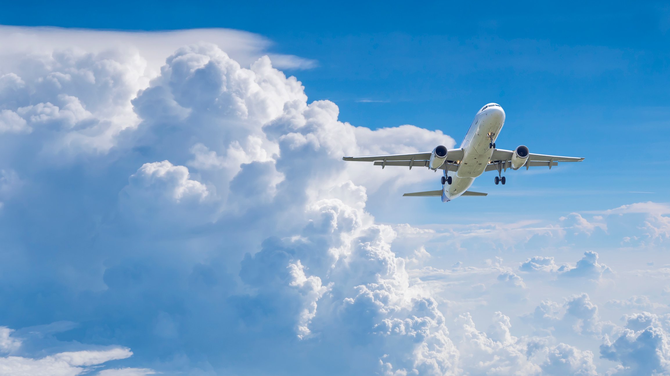 A plane rises through the clouds.