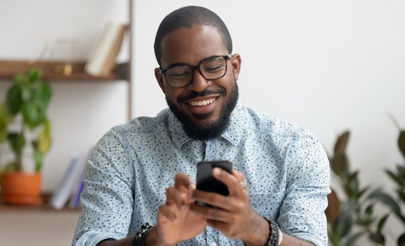 Man looking at his smartphone and smiling