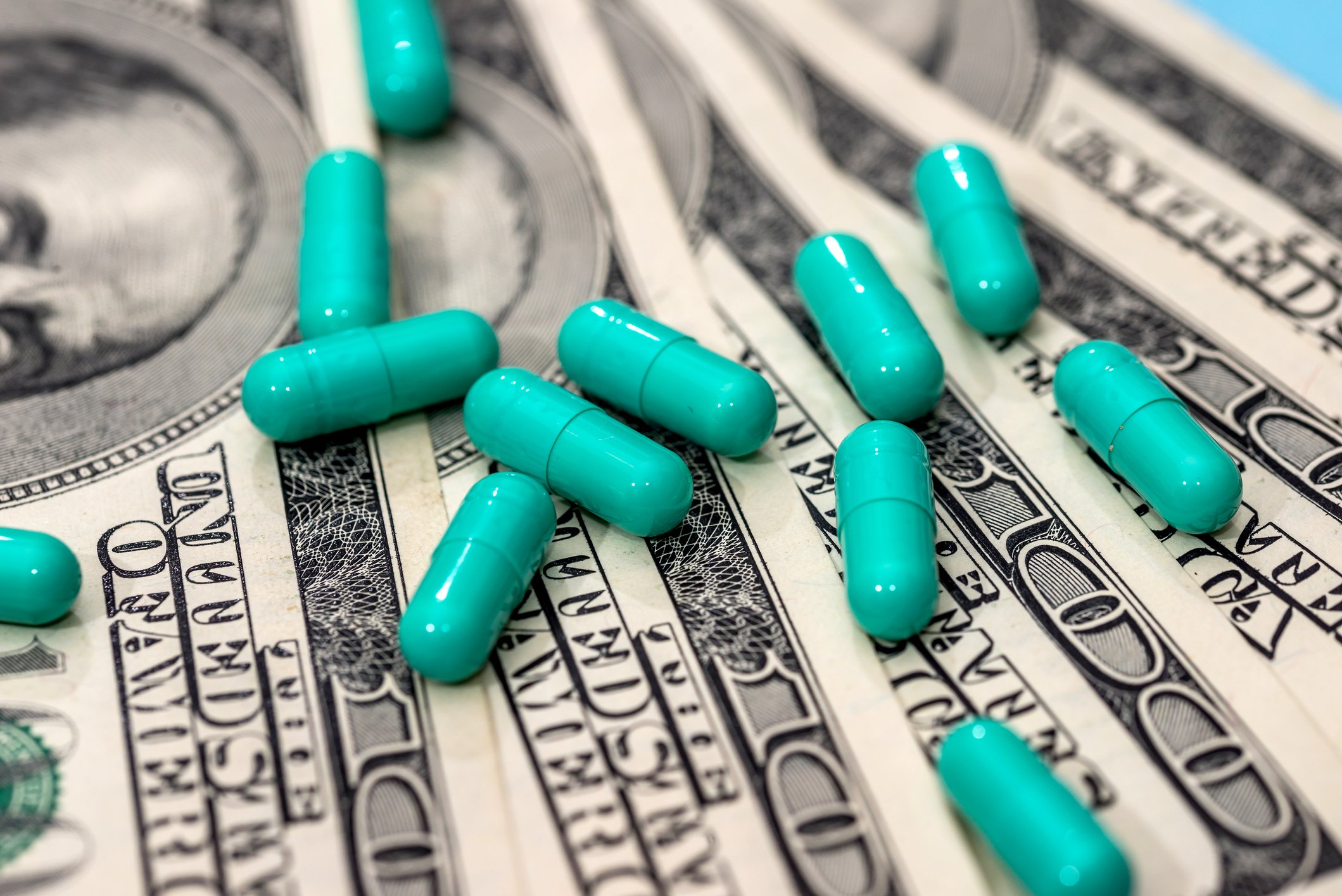 drug capsules on top of $100 bills
