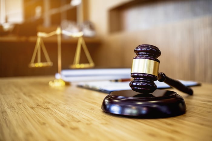 A gavel rests on a table in a court room.