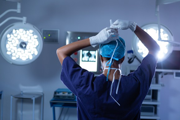Practitioner wearing surgical mask in operating room. 