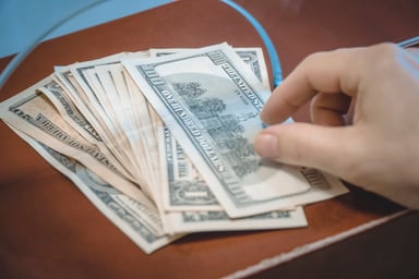 Money being passed through a bank teller window