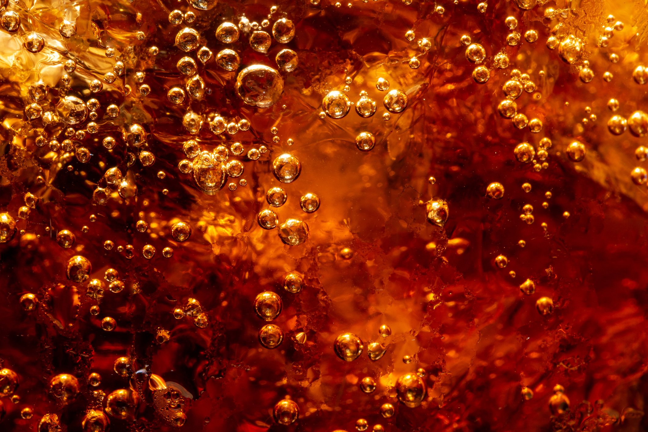Closeup of dark carbonated soft drink with ice.